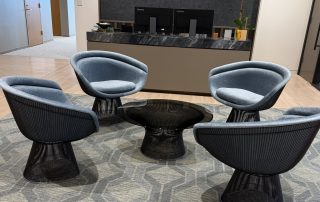 : A patterned gray rug installed by Oscar Isberian Rugs anchors the reception seating at Newmark’s Chicago offices in Salesforce Tower, Wolf Point.
