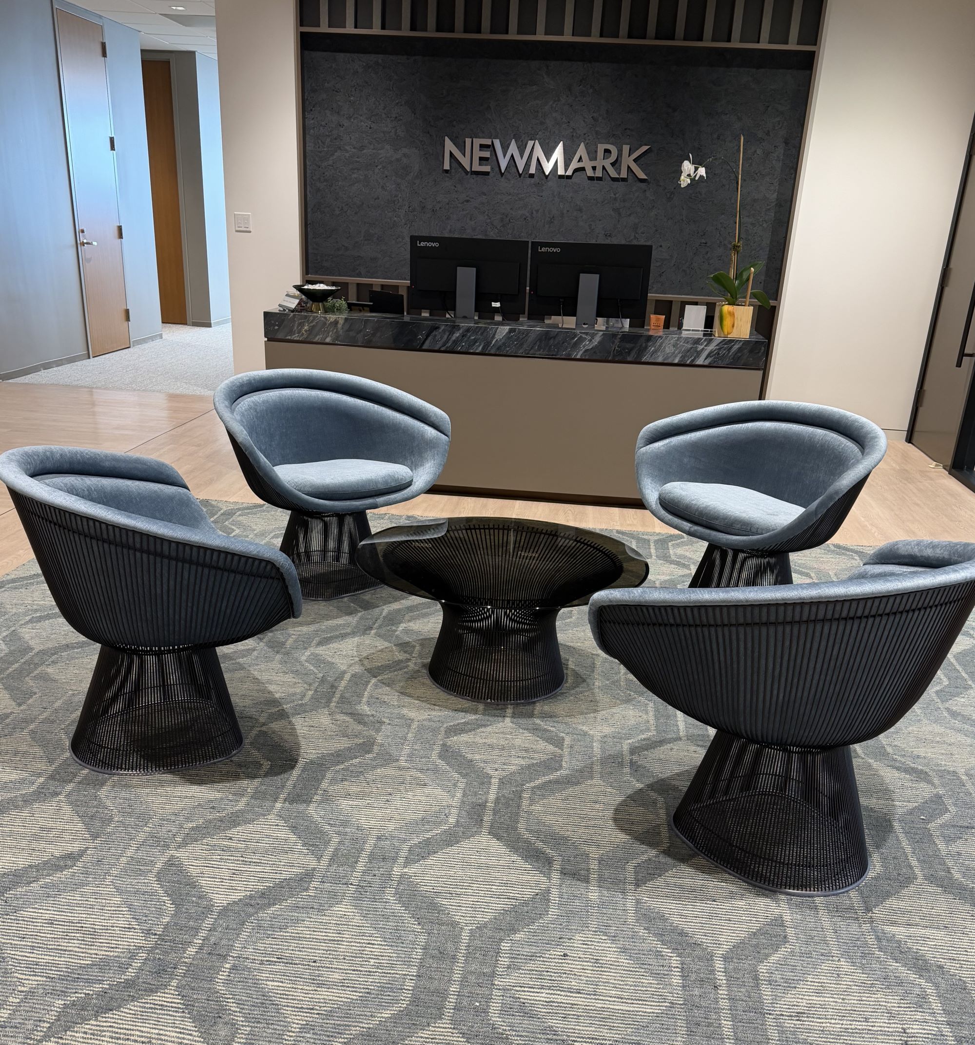 : A patterned gray rug installed by Oscar Isberian Rugs anchors the reception seating at Newmark’s Chicago offices in Salesforce Tower, Wolf Point.